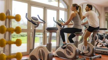 A gym with stationary bikes and a large window.