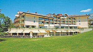 A multi-story hotel with balconies, outdoor seating, and a grassy lawn. - Hotel & Spa Vacances Bleues Villa Marlioz (Aix-les-Bains)