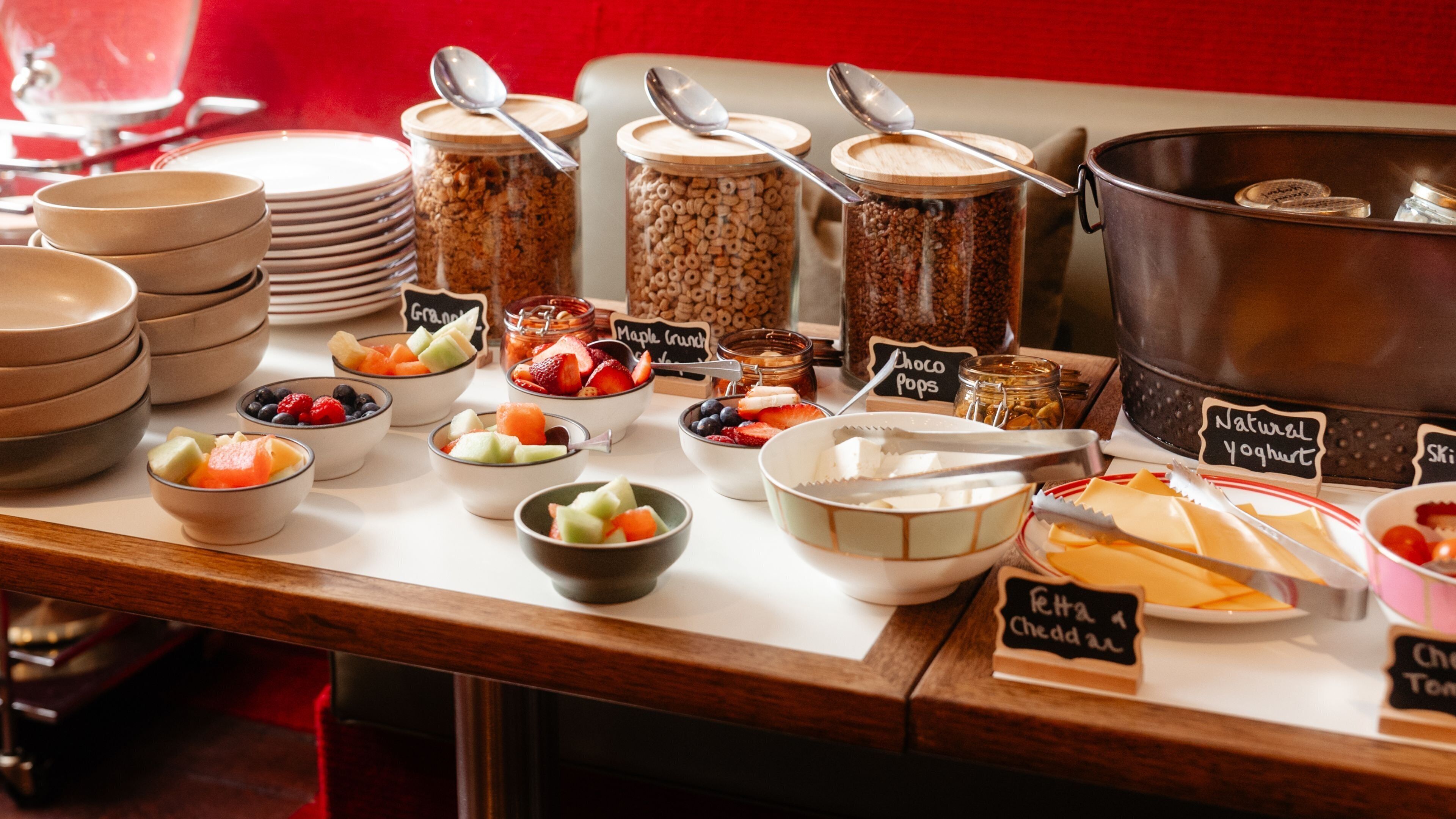 A breakfast buffet with various food items and labels.