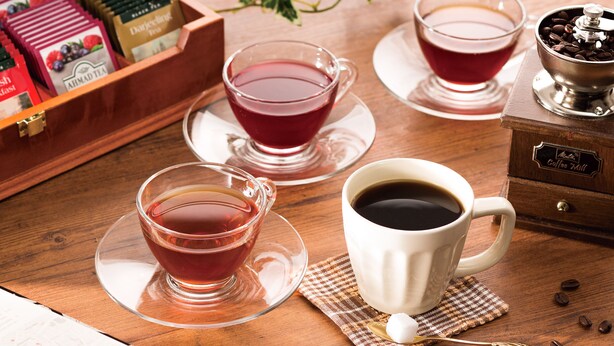 A wooden table with three cups of tea, a coffee grinder, and a box of tea bags. - Comfort Hotel Sendai West (Sendai)