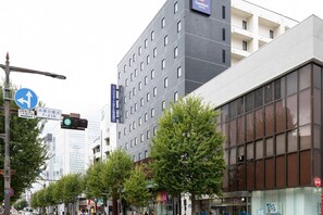 A modern building with a sign for a Comfort Hotel, a traffic light, and a pedestrian crossing. - Comfort Hotel Sendai West (Sendai)