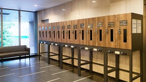 A row of wooden lockers with numbered labels, a bench, and a tiled floor. - Comfort Hotel Sendai West (Sendai)