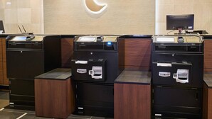 A self-service kiosk area with multiple HP printers and a large illuminated logo on the wall. - Comfort Hotel Sendai West (Sendai)