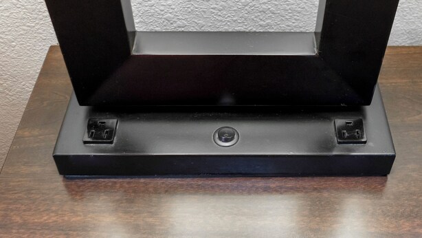 A black electronic device with two power outlets on a wooden surface. - Red Roof Inn Arlington - Entertainment District (Arlington)