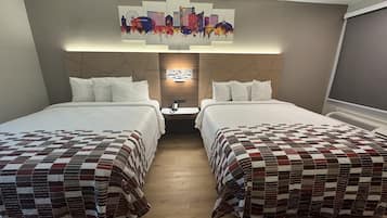 A hotel room with two beds, a cityscape artwork on the wall, and a modern headboard design.