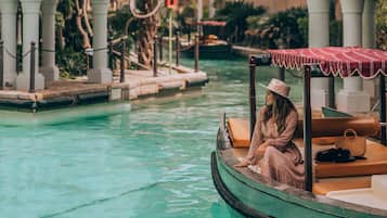 Guests can enjoy a serene waterway view from a traditional structure with arches and a patterned facade.