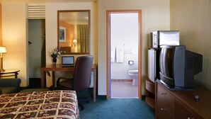 A hotel room with a bed, desk, chair, television, and a bathroom visible through an open door. - Americas Best Value Inn Livermore (Livermore)