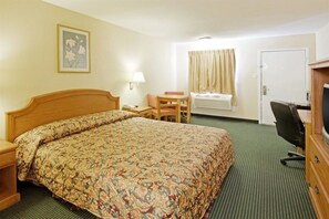 A hotel room with a bed, a desk, a chair, a television, and a window with curtains. - Americas Best Value Inn Gainesville, TX (Gainesville)