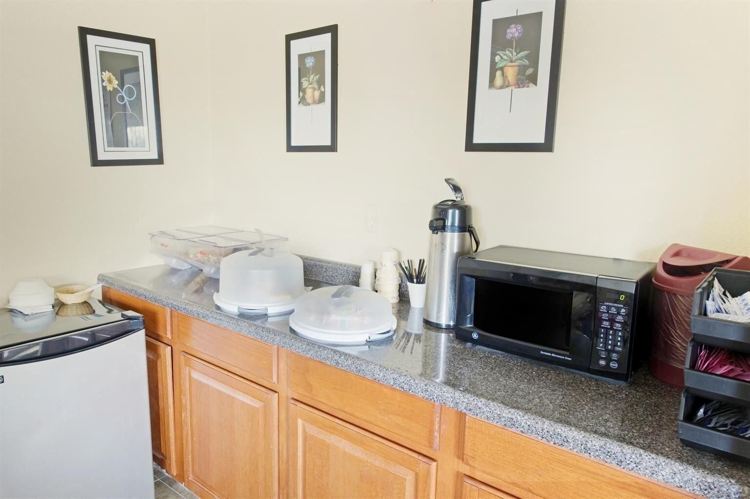 A kitchen with a microwave, a coffee maker, and a refrigerator.