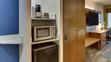 A compact kitchenette with a microwave, coffee maker, and refrigerator.