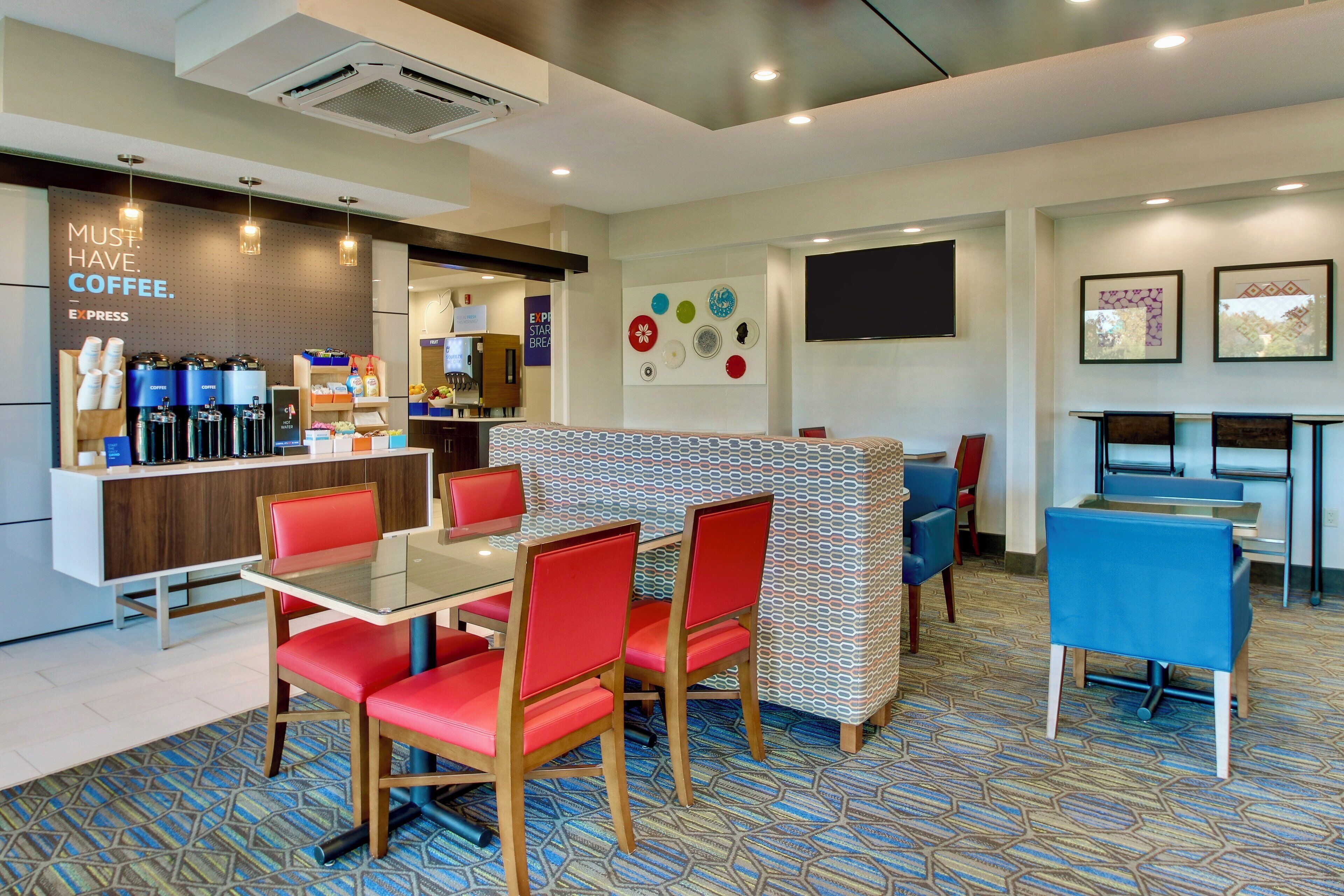 A modern cafe with a coffee bar, seating area, and art on the walls.