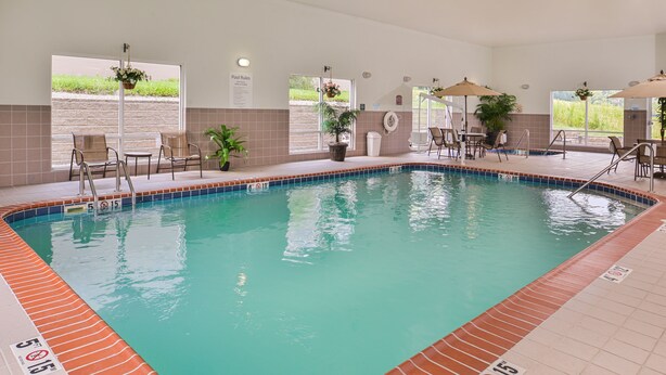 Una piscina interior con agua cristalina, bordes de azulejos y carriles numerados.