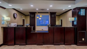 A reception desk with a clock, a Holiday Inn Express sign, and a check-in counter. - Holiday Inn Express & Suites Pampa by IHG (Pampa)