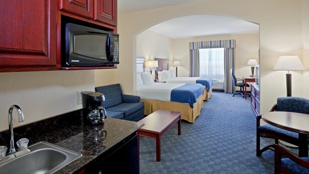 A hotel room with a kitchenette, a bed, a desk, and a seating area. - Holiday Inn Express & Suites Pampa by IHG (Pampa)