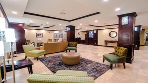 A lobby with a reception desk, seating area, and a clock on the wall. - Holiday Inn Express & Suites Pampa by IHG (Pampa)