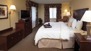 Ein Hotelzimmer mit Bett, Fernseher, Schreibtisch und Lampe.