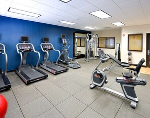 A gym with treadmills, elliptical machines, and weight equipment.