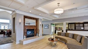 A spacious living area with a fireplace, a sofa, a coffee table, and a bookshelf.