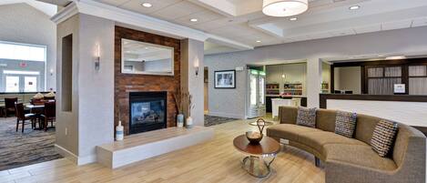 A spacious living area with a fireplace, a sofa, a coffee table, and a bookshelf.