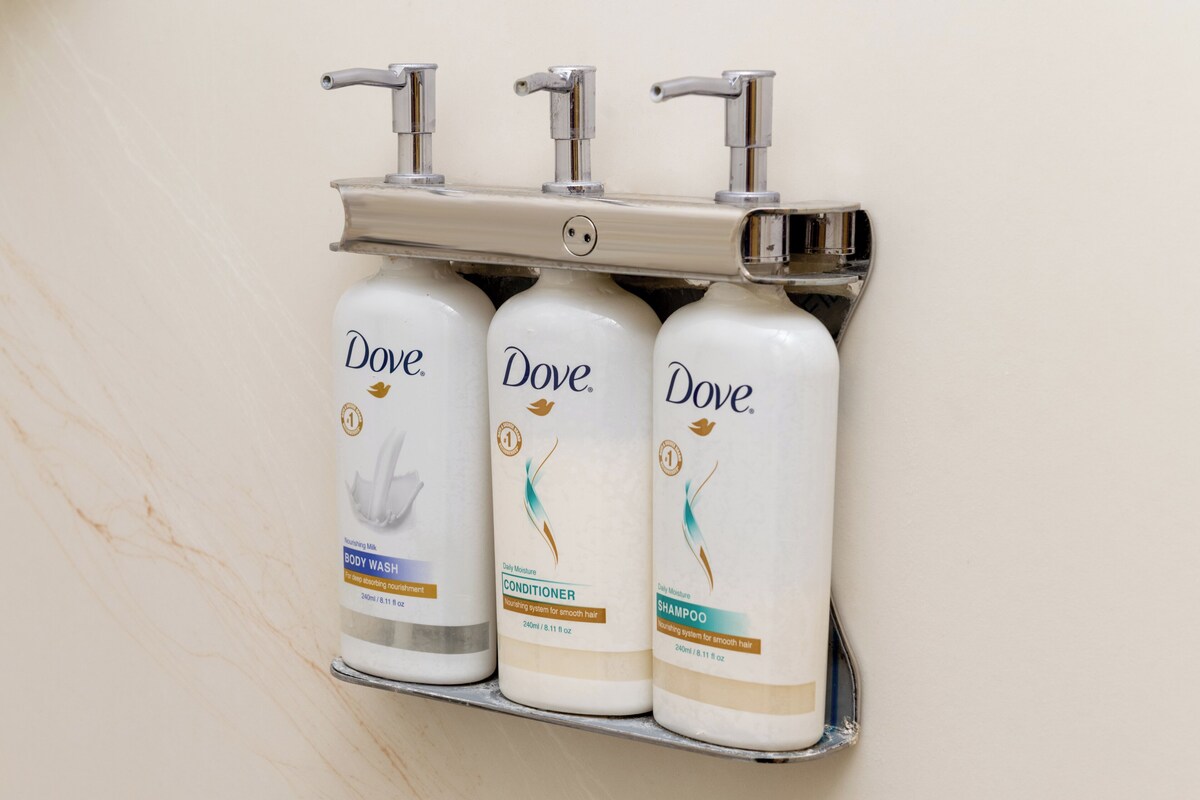 Drei Dove Duschgels auf einem an der Wand befestigten Regal.