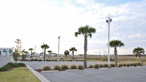 A parking lot with palm trees and a street lamp. - Grand Beach Condominiums by Wyndham Vacation Rentals (Gulf Shores)