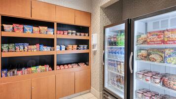A snack and beverage section with shelves stocked with various snacks and a refrigerated display case with beverages.