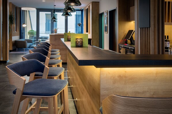 A modern bar area with wooden bar stools and pendant lighting. - Holiday Inn Express Baden-Baden by IHG (Baden-Baden)