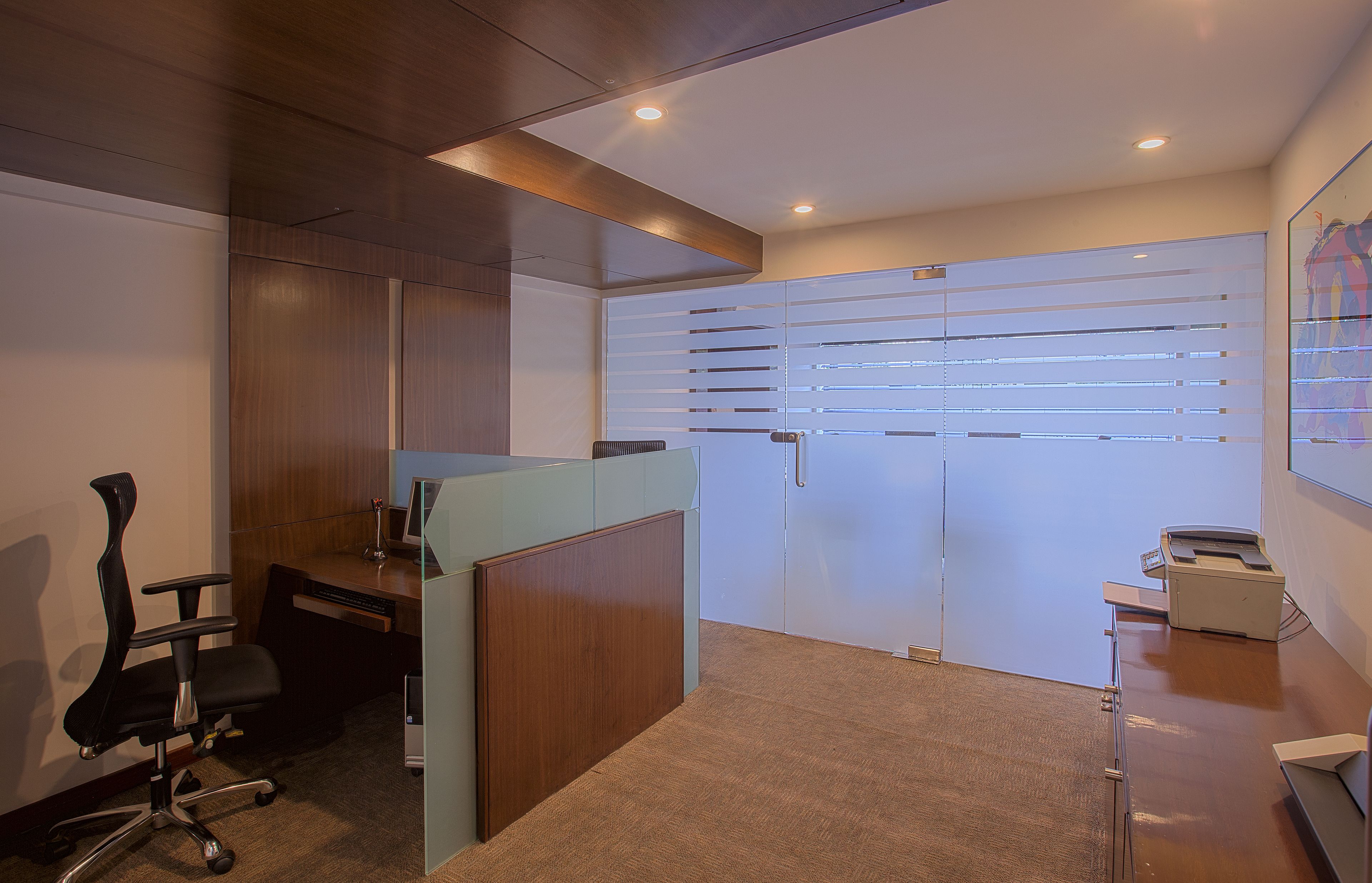 A modern office space with a desk, chair, and a filing cabinet.