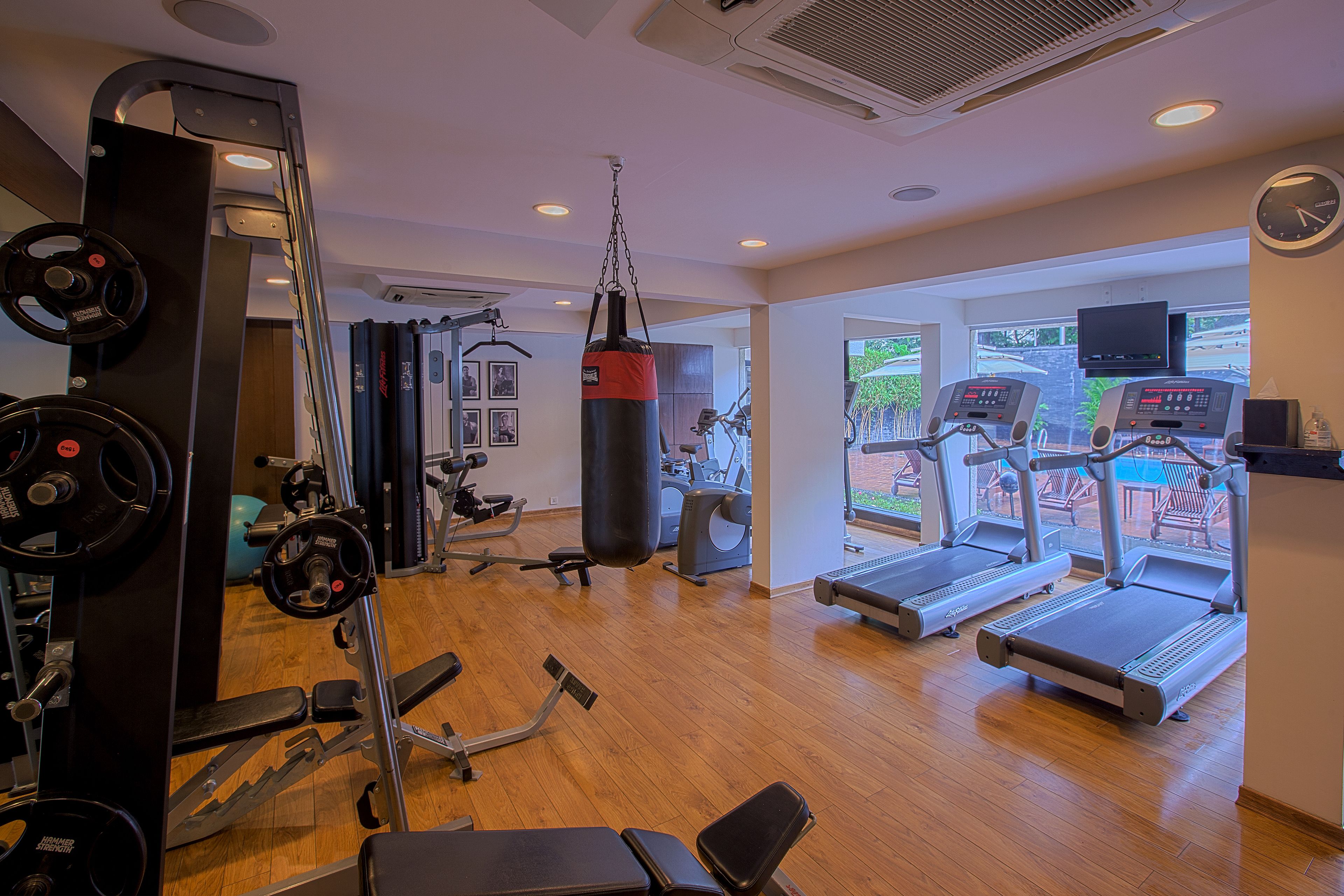 A gym with cardio equipment, weight machines, and a punching bag.