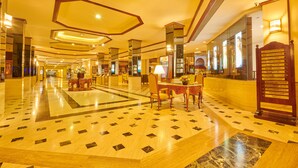A hotel lobby with a geometric patterned floor, a reception desk, and directional signs. - Galadari Hotel (Colombo)