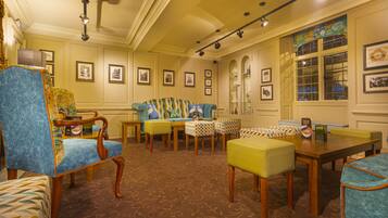 A room with a patterned carpet, a wooden coffee table, and a sofa with a patterned cushion.