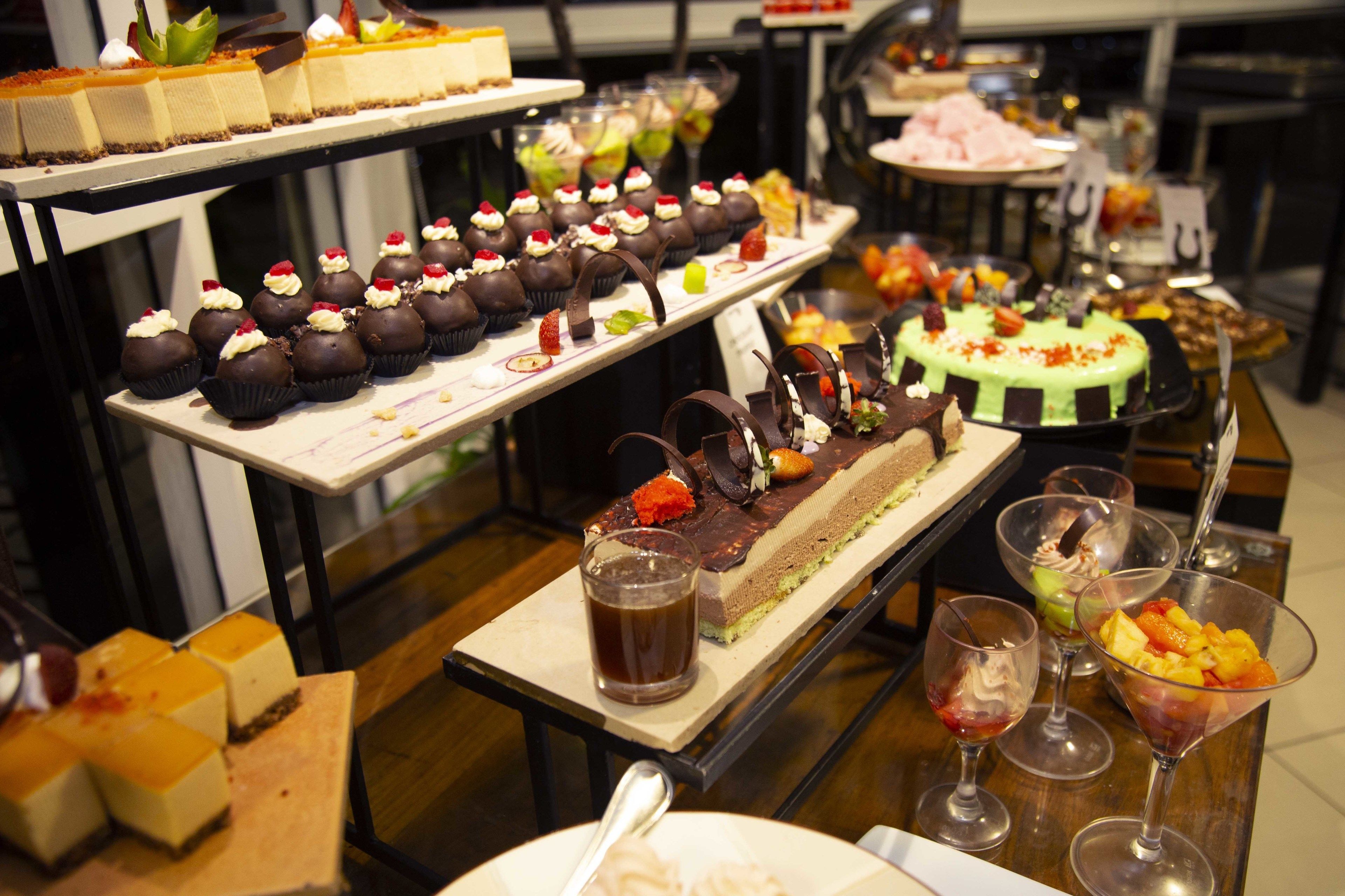 Un bufé con diversos postres y bebidas.