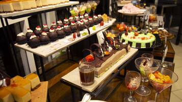 Un bufé con diversos postres y bebidas.