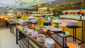 A buffet with various food and drink options, including salads, meats, and a selection of juices.