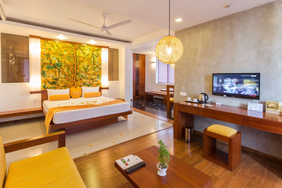 Una habitación de hotel moderna con cama, escritorio y televisor.