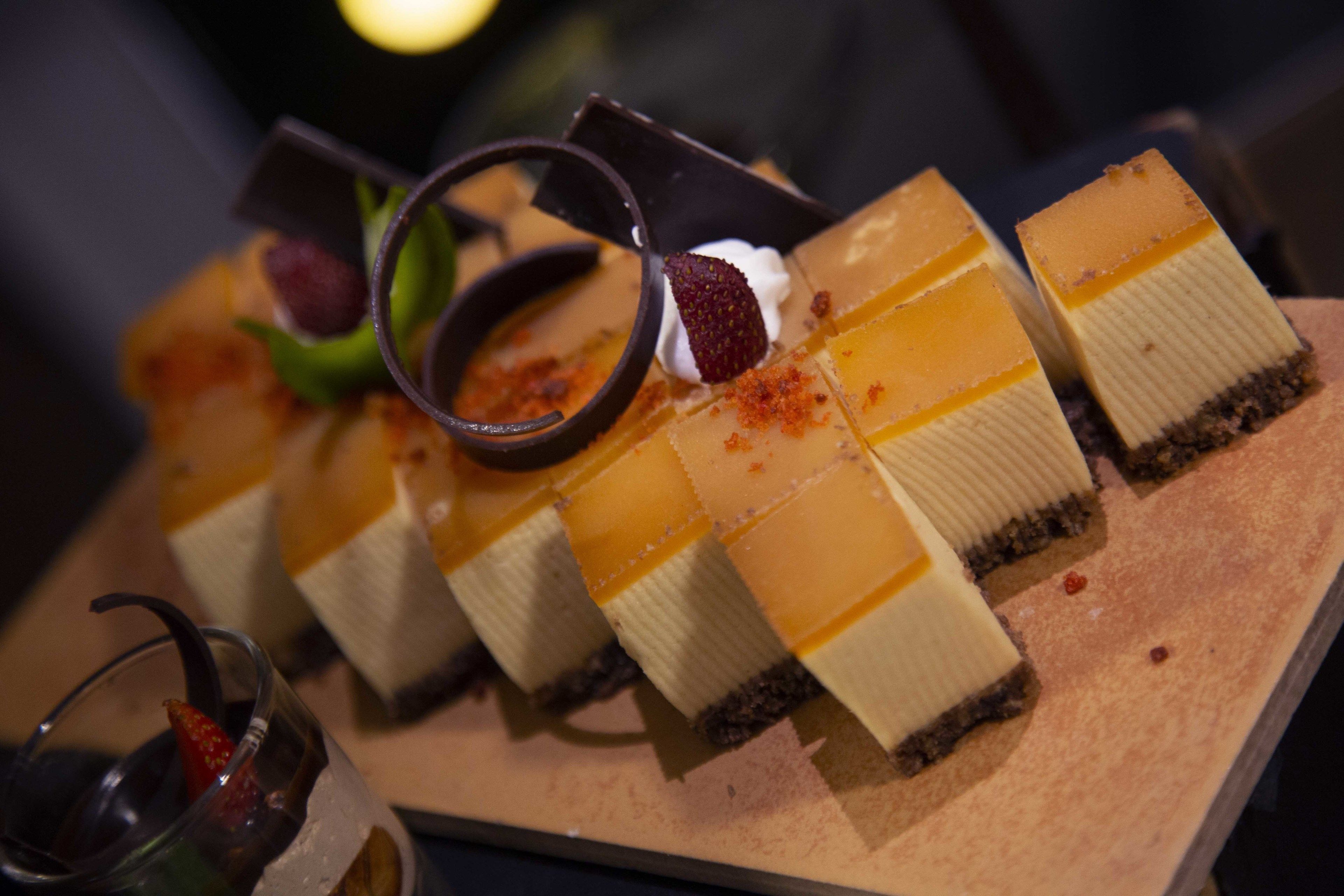 A dessert platter with various sweets and a chocolate cup.