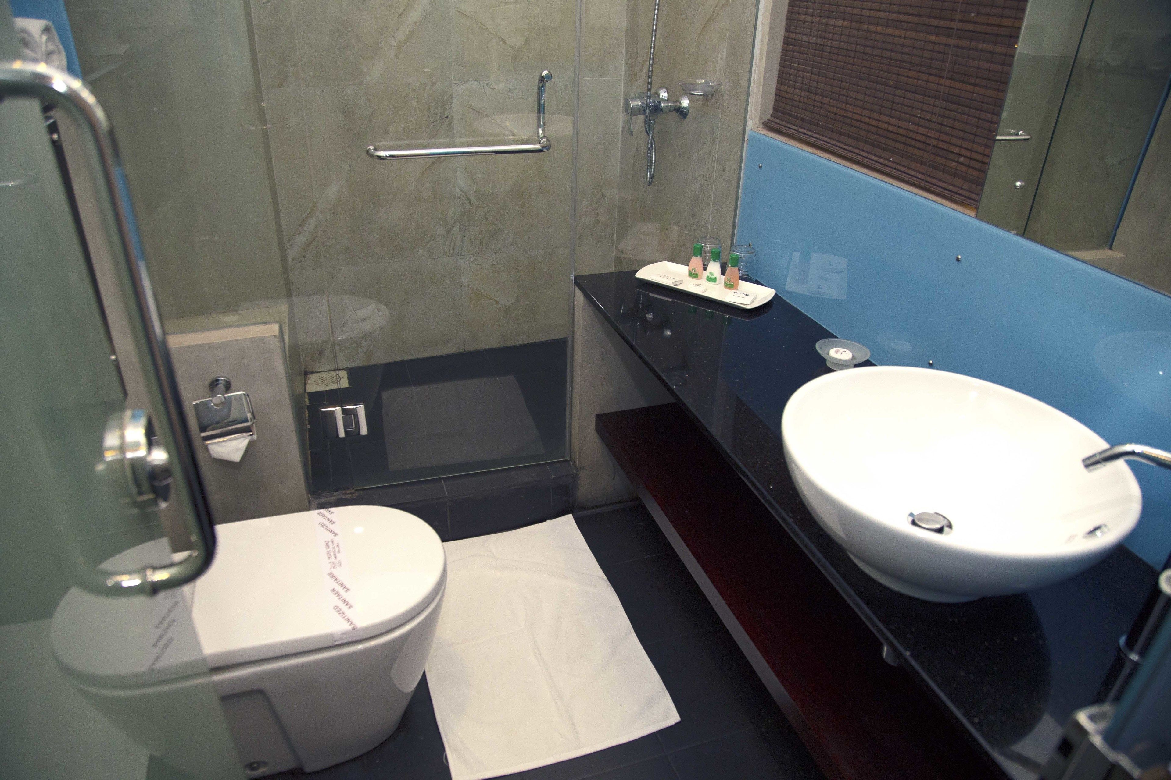 A modern bathroom with a toilet, a sink, and a shower area.
