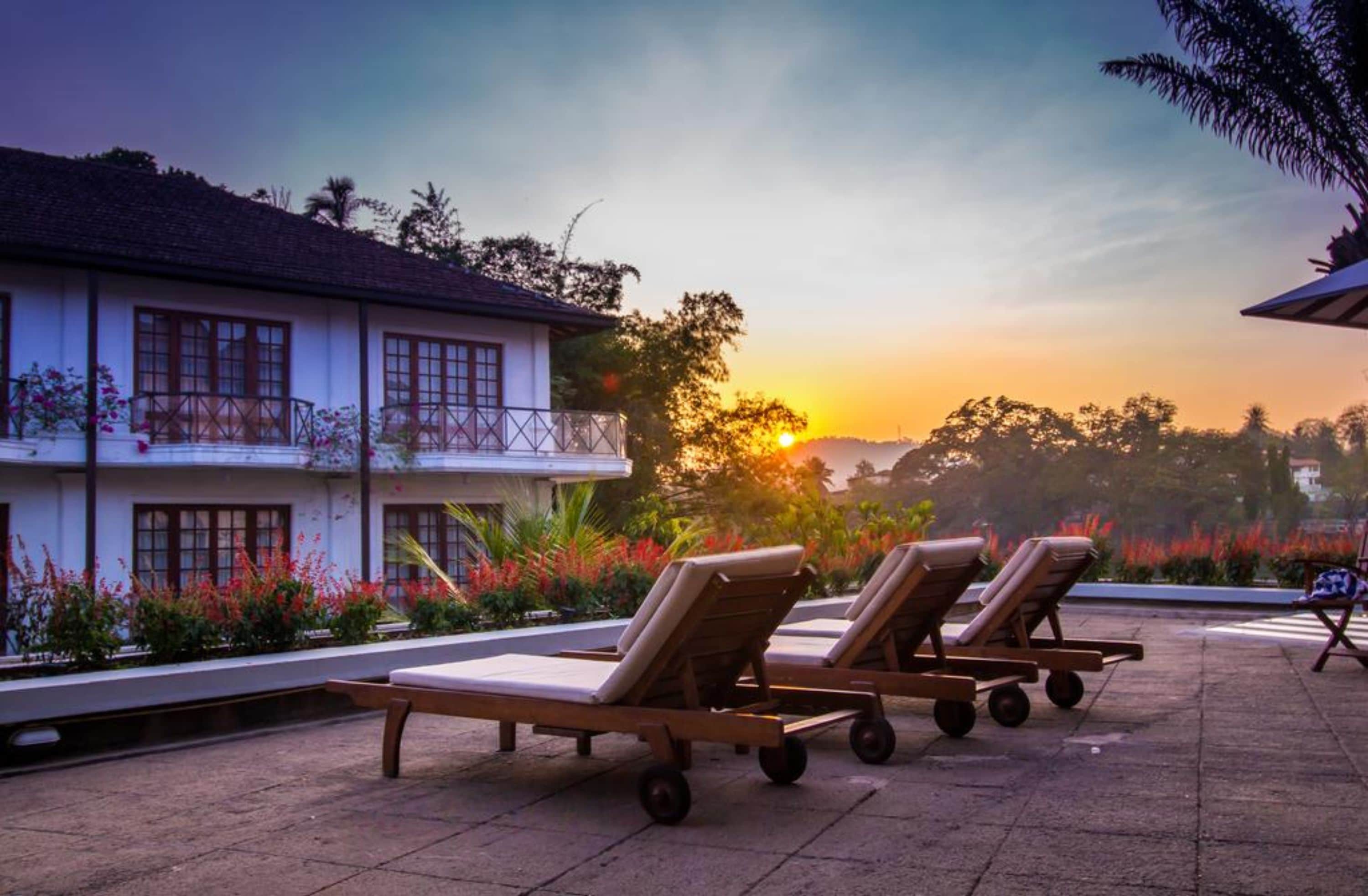A resort with a pool area, lounge chairs, and a building with balconies overlooking the pool.