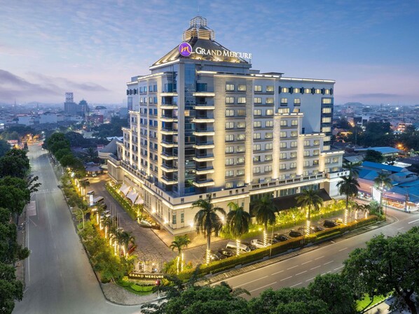A multi-story hotel with a prominent 'Grand Mercury' sign, a landscaped courtyard, and a view of the surrounding cityscape. - Grand Mercure Medan Angkasa (Medan)