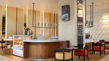 Un vestíbulo de hotel moderno con una recepción, zona de estar y un panel de menú.