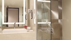 A modern bathroom with a large mirror, a sink, a glass-enclosed shower, and a towel rack. - Grand Mercure Medan Angkasa (Medan)