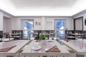 A conference room with multiple tables, chairs, and a large window. - Best Quality Hotel Dock Milano (Turin)