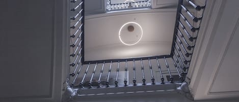 A staircase with a skylight and a circular light fixture.