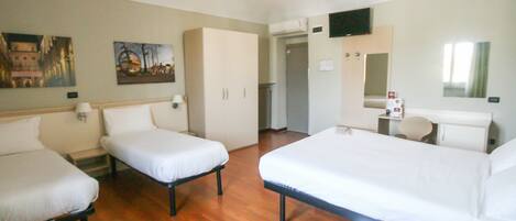 A hotel room with two single beds, a desk with a chair, a television, and a mirror.