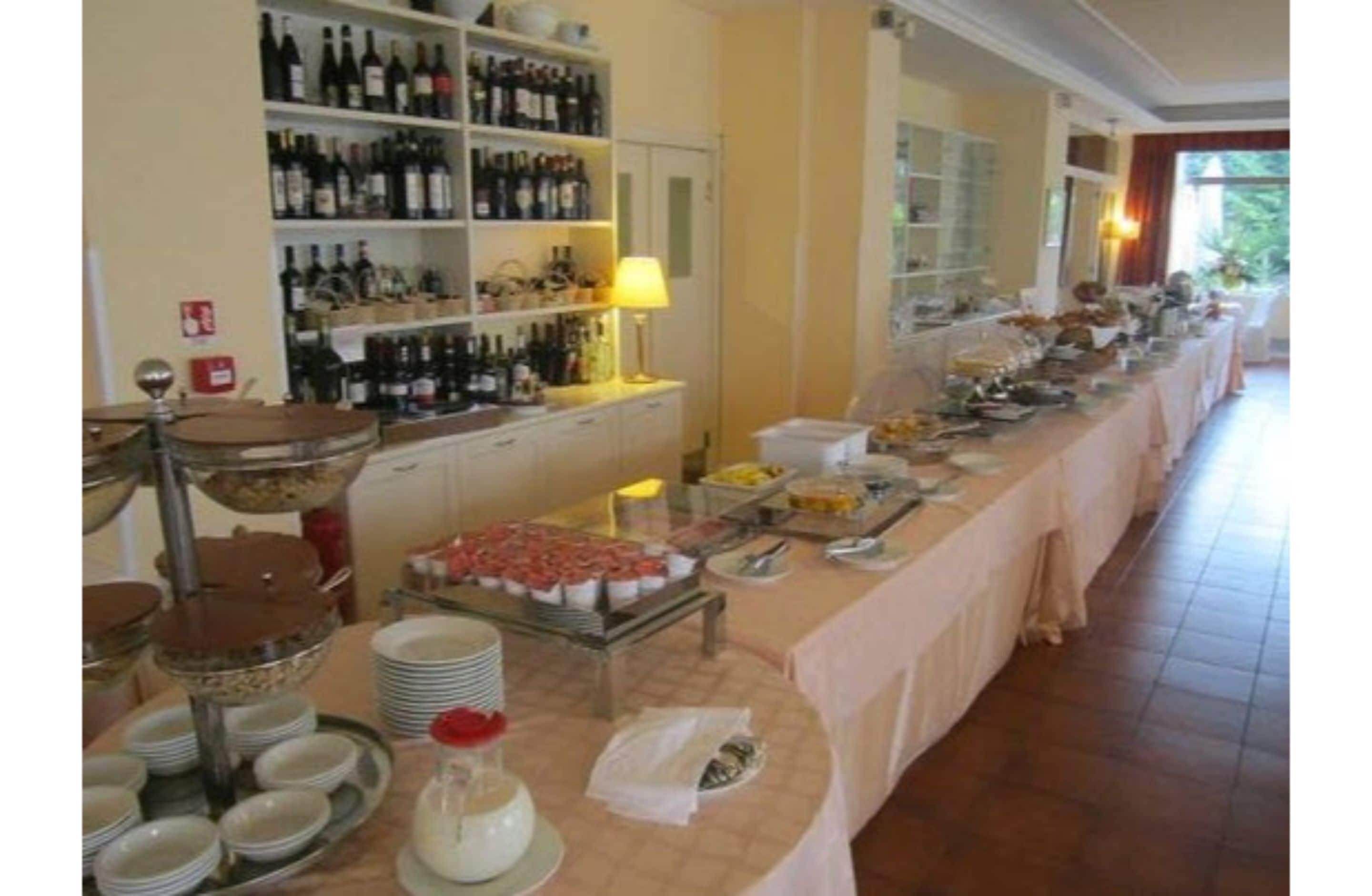 A buffet setup with various food items and a wine selection.