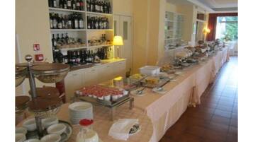 A buffet setup with various food items and a wine selection.