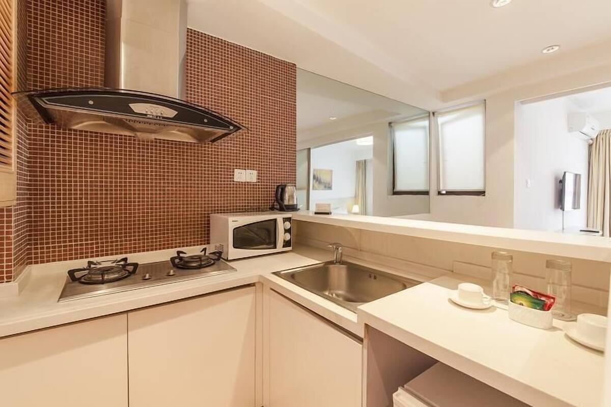 A modern kitchen with a gas stove, microwave, and stainless steel sink.