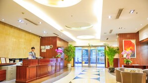 A hotel lobby with a reception desk, seating area, and potted plants. - Eastern Garden Service Apartment (Shanghai)