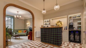 Un hall d’hôtel moderne avec un comptoir d’enregistrement, un espace salon et un sol à motifs.