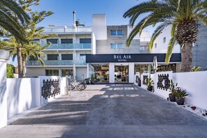 The entrance to the Bel Air Hotel, featuring a modern architectural design with a prominent entrance, a covered walkway, and a parking area with bicycles. - Bel Air Hotel (Castelldefels)